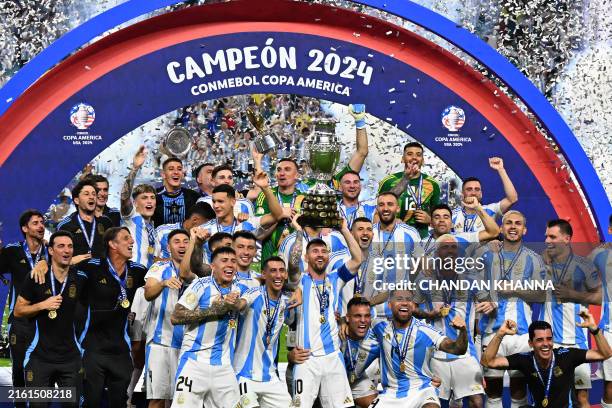 Argentina's forward Lionel Messi lifts up the trophy as he celebrates winning the Conmebol 2024 Copa America tournament final football match between...