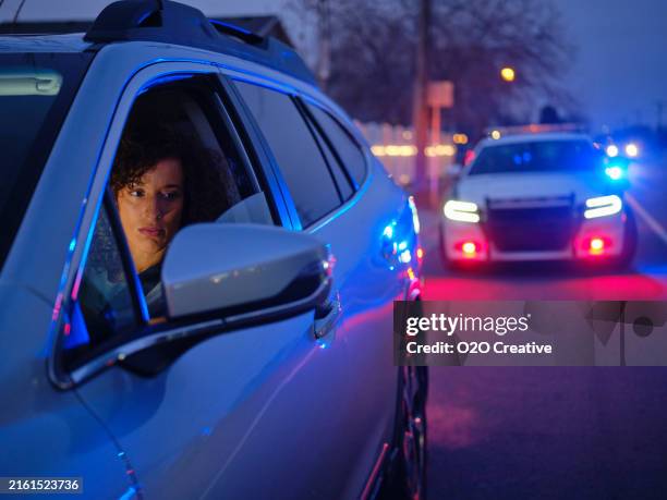 young woman driver pulled over by police at night - alkohol am steuer stock-fotos und bilder