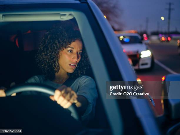 junge fahrerin wird nachts von der polizei angehalten - verkehrskontrolle stock-fotos und bilder