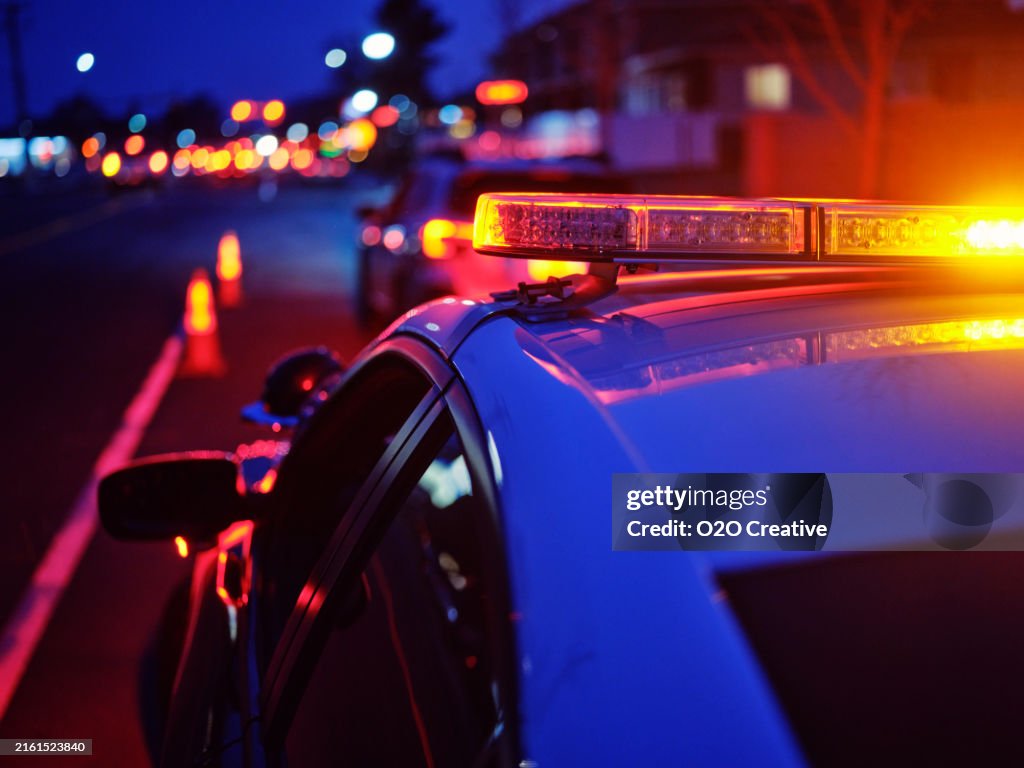 Police Car Stopped on a Road at Night with Emergency Lights