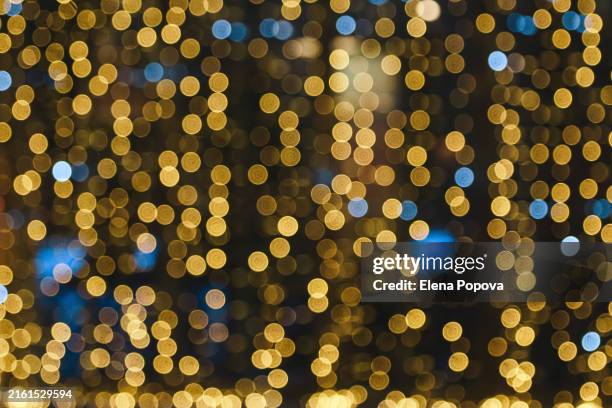full frame glittering christmas garland decorations in the city, illuminating city street - gold christmas garland stock pictures, royalty-free photos & images