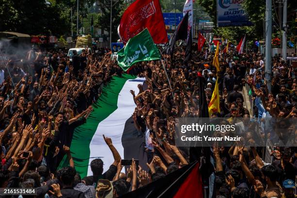 Kashmiri Shi'ite mourners carry a Palestinian flag during a Muharram procession ahead of Ashura to show solidarity with Palestinians on the 8th of...