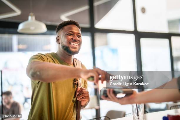 young student mobile paying in a coffee shop. - payment bildbanksfoton och bilder