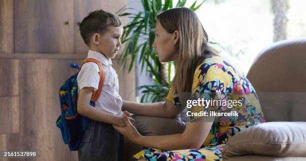 concepto de vuelta al cole. un estudiante preocupado por el primer día de clases. madre consolando a su hijo. - primer-dia-de-clase fotografías e imágenes de stock