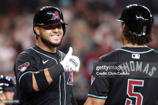 Eugenio Suárez of the Arizona Diamondbacks gives a thumbs up to Alek Thomas after hitting a two run home run against the Atlanta Braves during the...