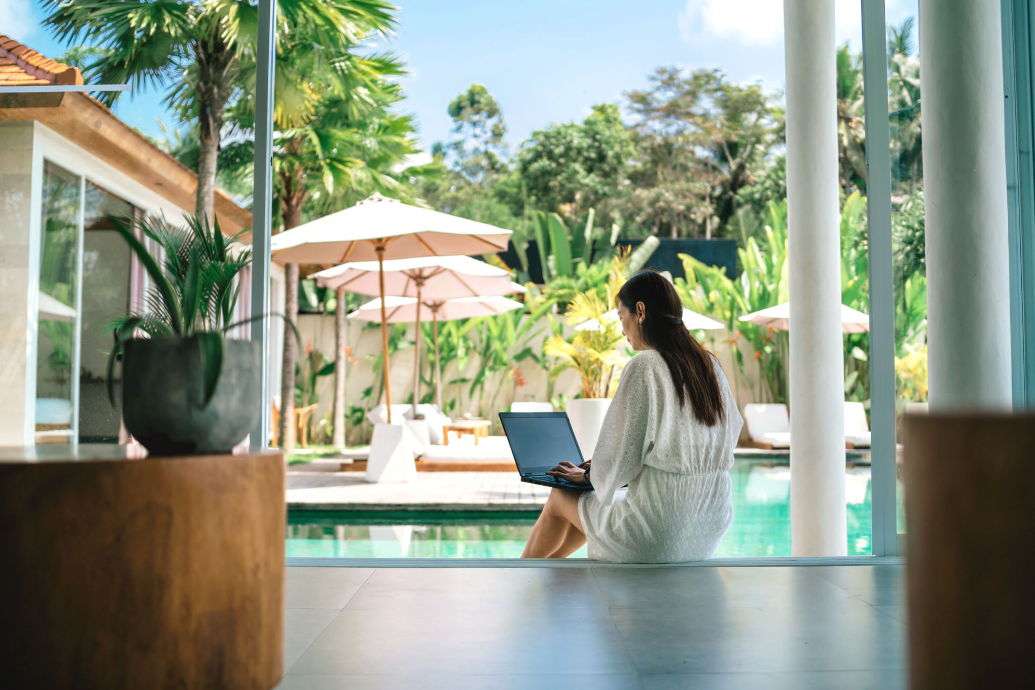woman working with laptop at poolside woman working with laptop at poolside
