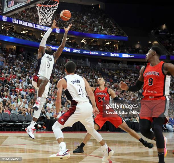 LeBron James of the United States dunks ahead of Dillon Brooks and RJ Barrett of Canada off of an alley-oop pass from Stephen Curry in the second...