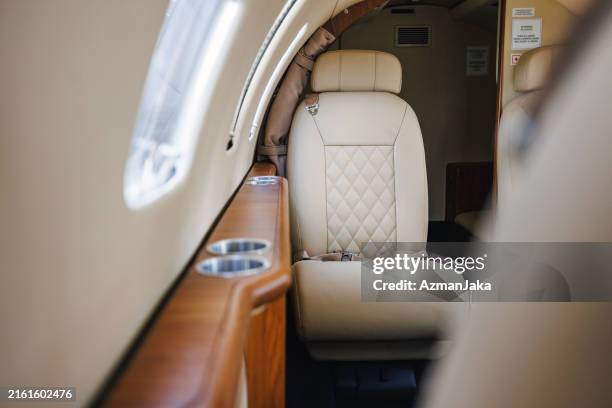 luxury private jet interior with leather seats and wood accents - corporate jet stock pictures, royalty-free photos & images