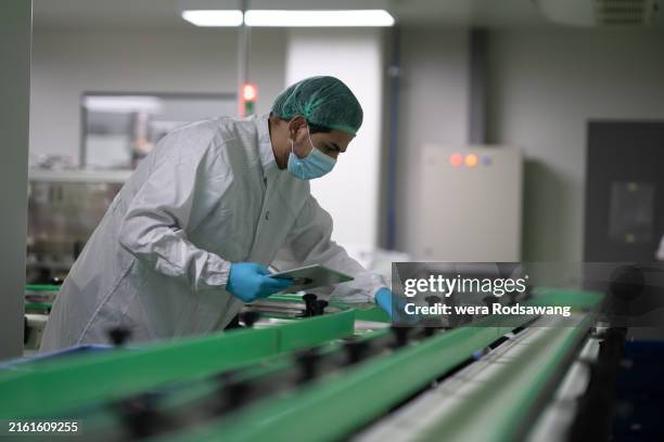 pharmacist monitor of conveyor belt machine working - farmaceutische-fabriek stockfoto's en -beelden
