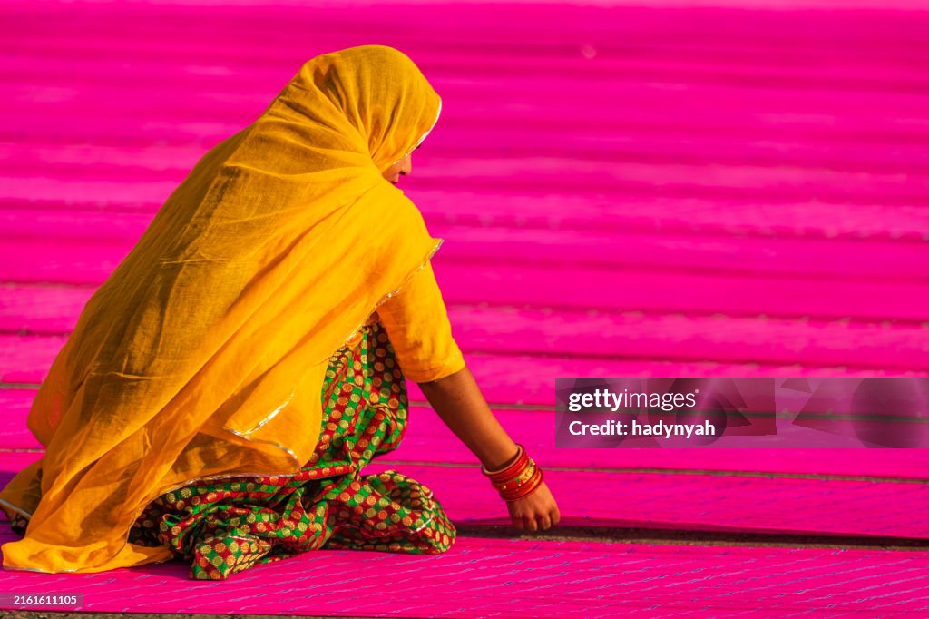Colors of India - woman checking dyed fabrics, Rajasthan, India