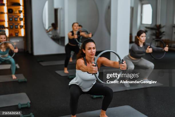 pilates ring squat da femmine atletiche in palestra - cerchio in metallo da pilates foto e immagini stock