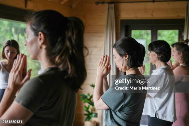 teacher explains yoga technique to diverse group - retreating stock pictures, royalty-free photos & images