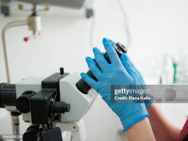 doctor's hands hold a medical microscope. a gynecologist's medical tool is a colposcope for examining the cervix. - colposcopy stock pictures, royalty-free photos & images
