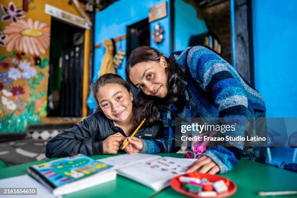 portrait of a teacher assisting student in the classroom at a children's foundation - zuid amerika stockfoto's en -beelden