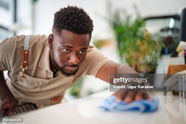 café-mitarbeiter mit mikrofaser-reinigungstuch. - mikrofaser stock-fotos und bilder