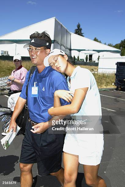 Michelle Wie walks out of the media center with her father/caddie BJ Wie during practice for the US Women's Open at Pumpkin Ridge Golf Club on July...