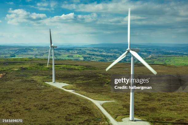 two large wind turbines on moor in west yorkshire - carbon neutrality stock pictures, royalty-free photos & images