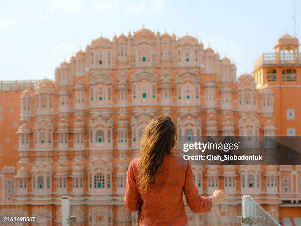 frau, die hawa mahal in jaipur, indien vom balkon aus betrachtet - mahal palace stock-fotos und bilder