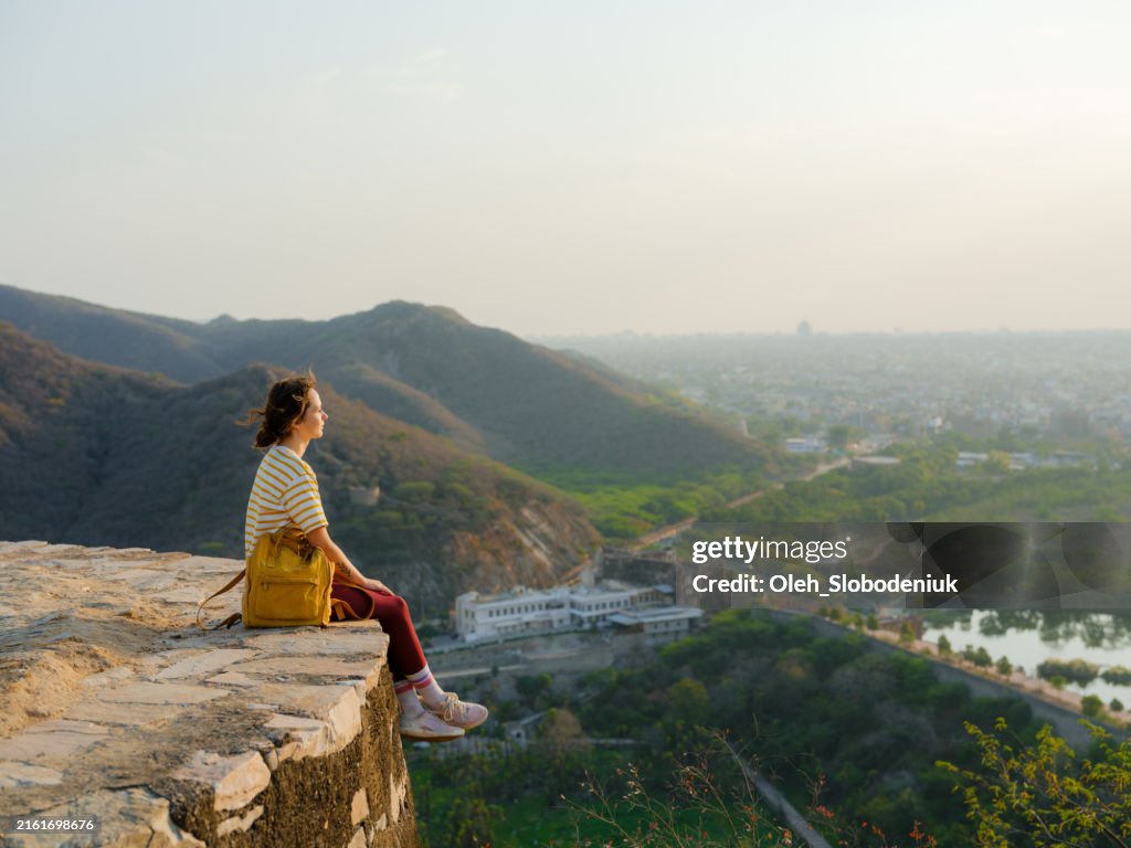 Woman looking at Jal Mahal in Jaipur from the mountains