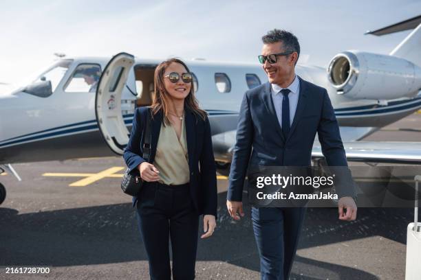 business professionals walking confidently from private jet - upper class stock pictures, royalty-free photos & images