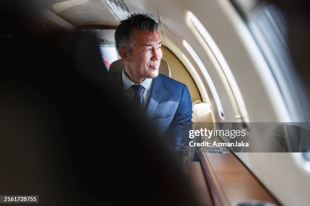 successful business executive contemplating in private jet - first class airplane stock pictures, royalty-free photos & images