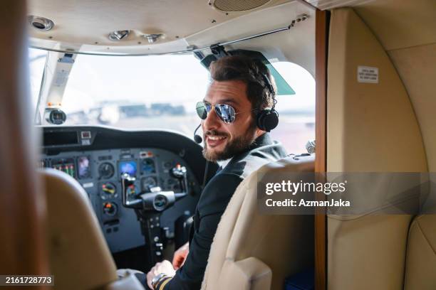 smiling pilot in private jet cockpit - portrait of professional aviator - private aeroplane stock pictures, royalty-free photos & images