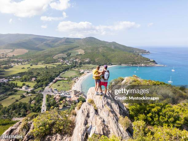 couple embracing on cliff with beautiful coastal view - corsica france stock pictures, royalty-free photos & images