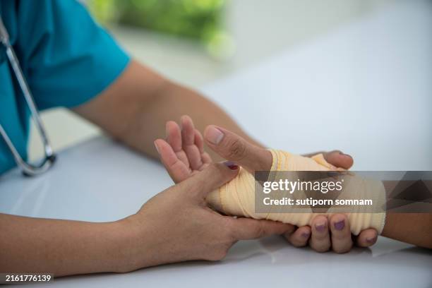 a doctor is helping a patient with a broken hand - wrapping arm stock pictures, royalty-free photos & images