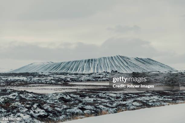 idyllic shot of snowcapped hverfjall against cloudy sky - myvatn stock pictures, royalty-free photos & images