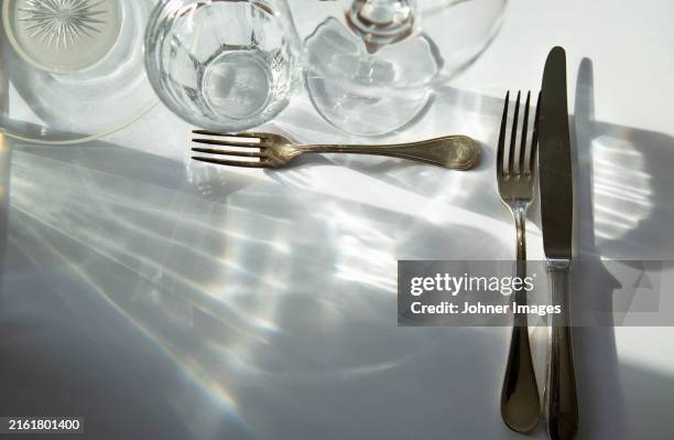directly above shot of forks and table knife with glasses on table - cubierto completo fotografías e imágenes de stock