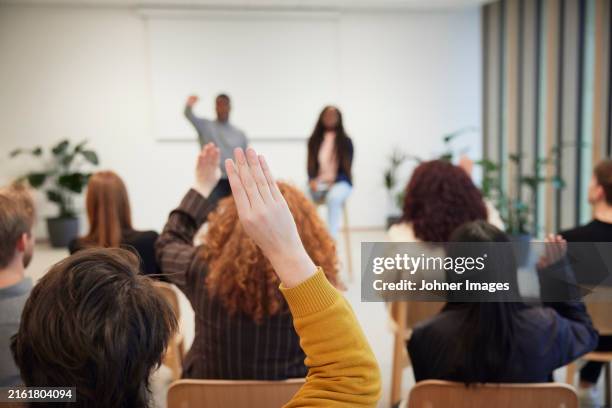 corporate colleagues raising hands during meeting in office - involvement stockfoto's en -beelden
