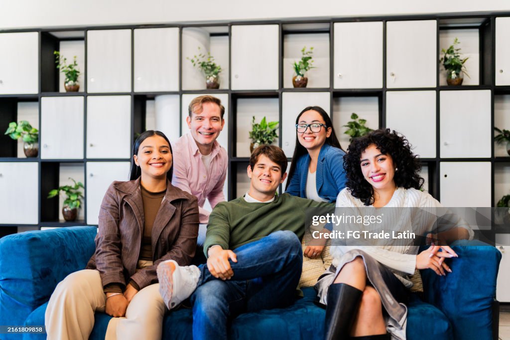 Porträt junger Coworker, die beim Coworking auf dem Sofa sitzen