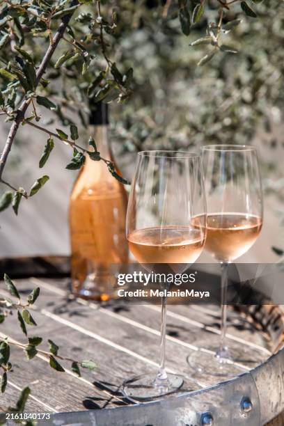copas de vino rosado y botella de vino de pie en un viejo barril de vino rústico bajo un roble en un viñedo francés para la cata de vinos - vino rosado fotografías e imágenes de stock