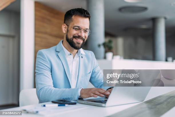 successful businessman in modern office working on laptop. - usar el ordenador fotografías e imágenes de stock