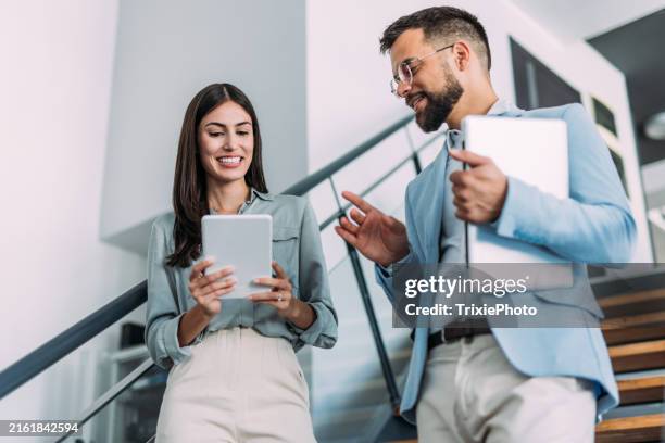 business colleagues talking on stairs in the office. - the next step stock pictures, royalty-free photos & images