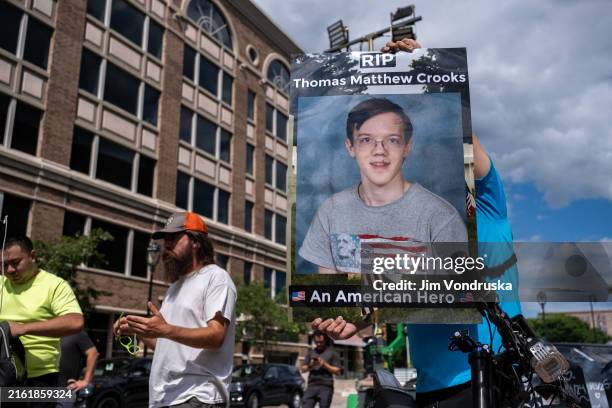 July 17: A demonstrator holds a sign of Thomas Matthew Crooks outside of a security zone checkpoint by the Fiserv Forum as the RNC continues on July...
