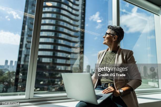 geschäftsfrau denkt über das büro nach - führungspersönlichkeit stock-fotos und bilder