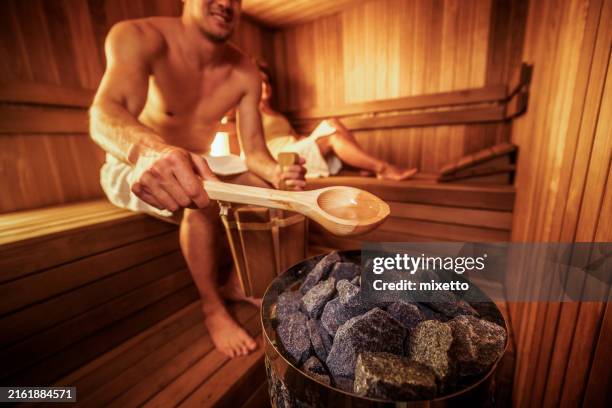 young couple enjoying their time together in sauna - sauna stockfoto's en -beelden