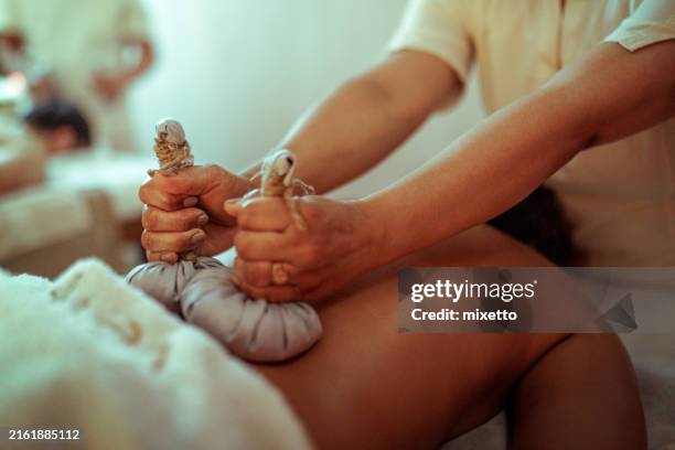 hot herbal ball spa massage body treatment - indulgence stock pictures, royalty-free photos & images