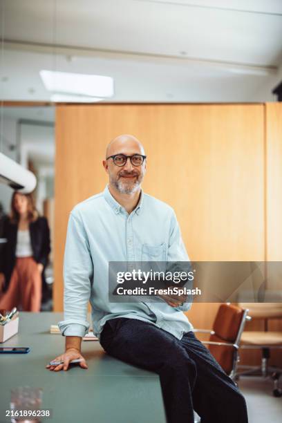 homme d’affaires confiant avec tablette dans un environnement de bureau moderne - chemise bleue femme photos et images de collection