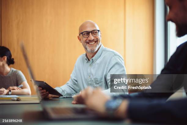 homme d’affaires souriant en équipe réunion avec des collègues au bureau - affaires photos et images de collection