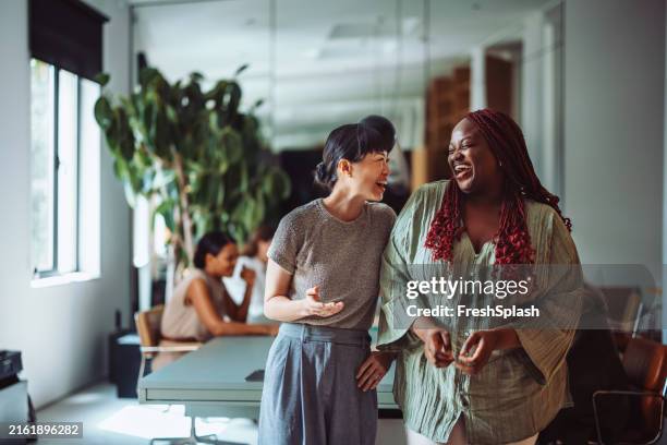 des collègues rient ensemble pendant la pause au bureau - collègue photos et images de collection