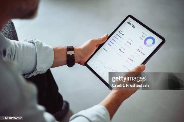 geschäftsmann, der finanzdaten auf einem digitalen tablet analysiert - tablet pc stock-fotos und bilder