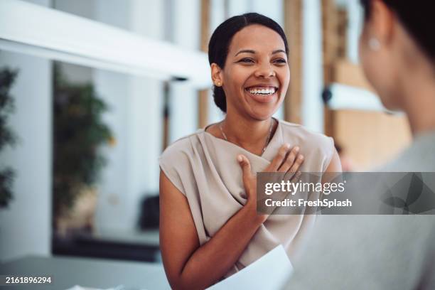 woman smiling and expressing gratitude during a conversation - dankbaarheid stockfoto's en -beelden