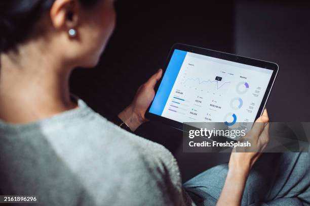 geschäftsfrau, die finanzdaten auf einem digitalen tablet analysiert - tablet pc stock-fotos und bilder