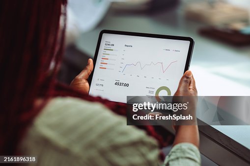 Femme d’affaires analysant des données financières sur un écran de tablette Femme d’affaires analysant des données financières sur un écran de tablette