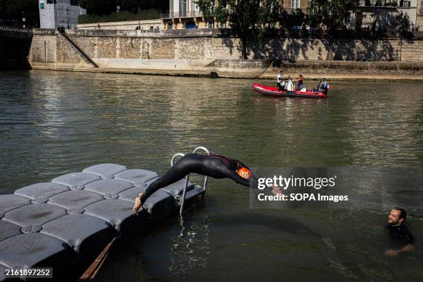 Person dives into the River Seine, after Paris Mayor Anne Hidalgo kept her promise of swimming in the Seine. Paris Mayor Anne Hidalgo swims in the...