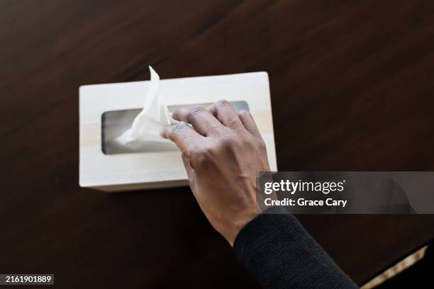 woman grabs a tissue from box - facial tissue stock pictures, royalty-free photos & images