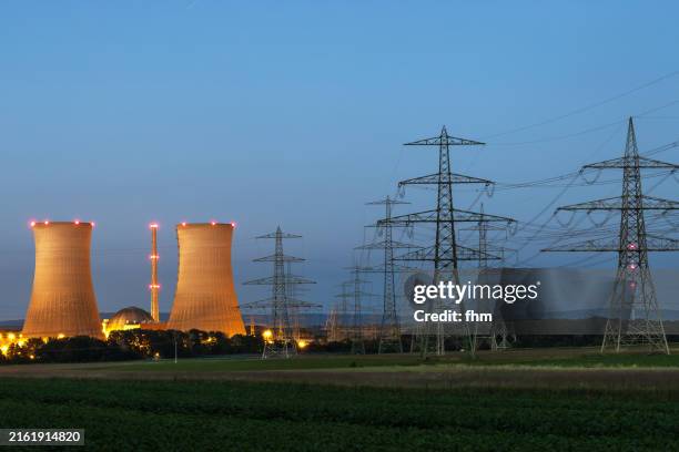 nuclear power plant with many electricity pylons at blue hour - grafenrheinfeld/ bavaria - kernenergie stock-fotos und bilder