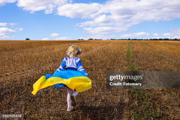 child in floral crown wrapped in ukrainian flag - ukrainian ethnic embroidery stock pictures, royalty-free photos & images